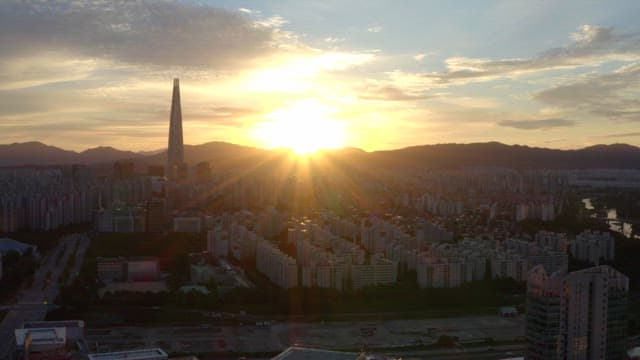Sunset over a city skyline with mountains