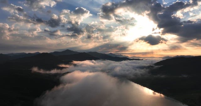 Sunlight breaking through clouds over mountains