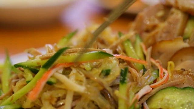 Chilled braised pigs' feet salad picked up with chopsticks