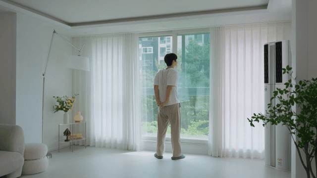Man opening curtains in modern living room in white interior