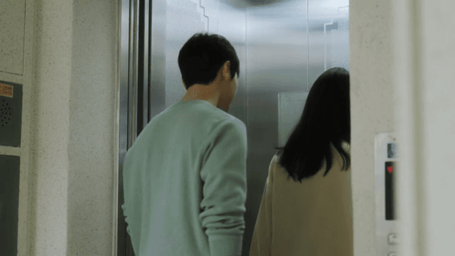 Two people waiting and getting on the elevator in an apartment building