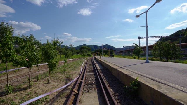 Railroad track leading into a mountainous landscape on a sunny day