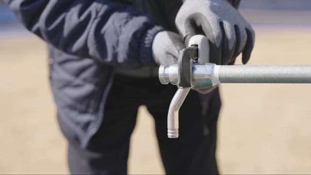 Person Operating an Outdoor Water Tap