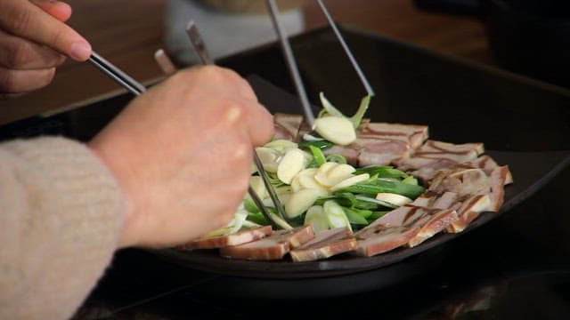 Eating boiled pork with garlic and green onions