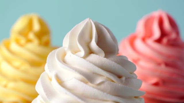 Cupcakes being decorated with colorful sprinkles