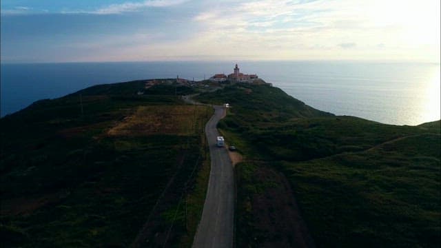 Coastal Road Leading to Lighthouse at Sunset