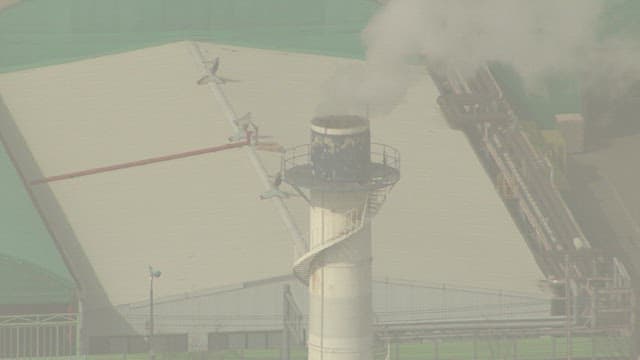 Aerial View of Industrial Complex with Smoke