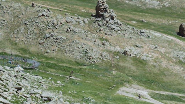 Man Riding Horse Through Mountainous Area