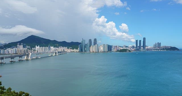 Panoramic cityscape of Busan with bridge near coastline on a clear day