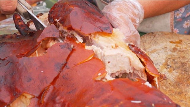 Lechon Baboy being sliced on a wooden board