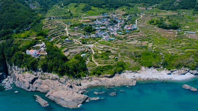 Aerial View of Coastal Village with Terraced Fields