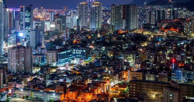 Night view of a bustling city with high-rise buildings and bright lights