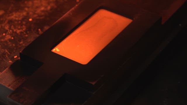 Molten metal being shaped in a mold