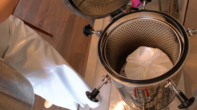 Pouring water into a metal container to make broth