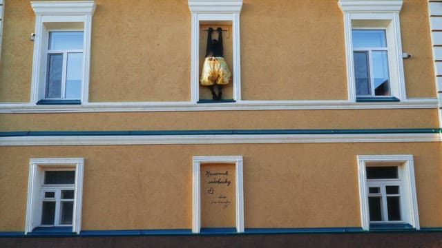 White window frames of a building decorated with letters and statues