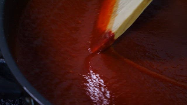 Red sauce being stirred in a pot