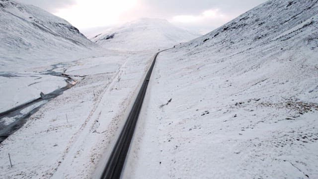 Snowy mountain road with a car