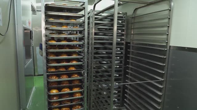 Freshly baked goods being wheeled out in a kitchen of bakery