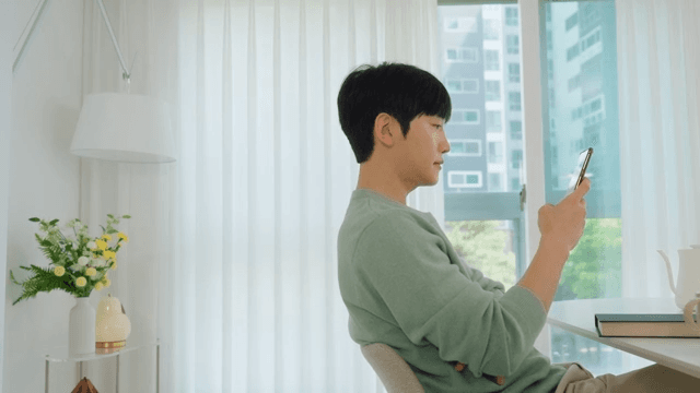 Man Using Smartphone by Window in Bright Living Room