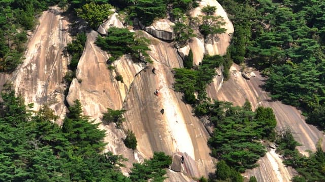 Climbers ascending a rocky mountain face