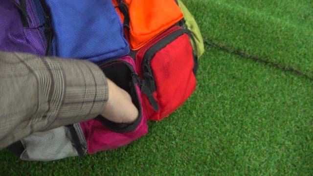 Otter searching through colorful bags