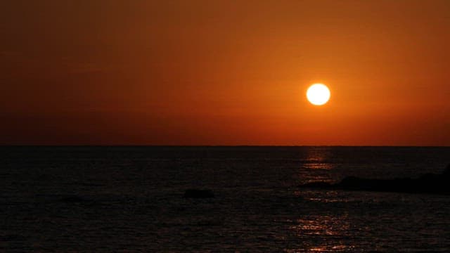 Sunset over the tranquil ocean horizon