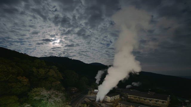 Clouds passing over a small village with mountains