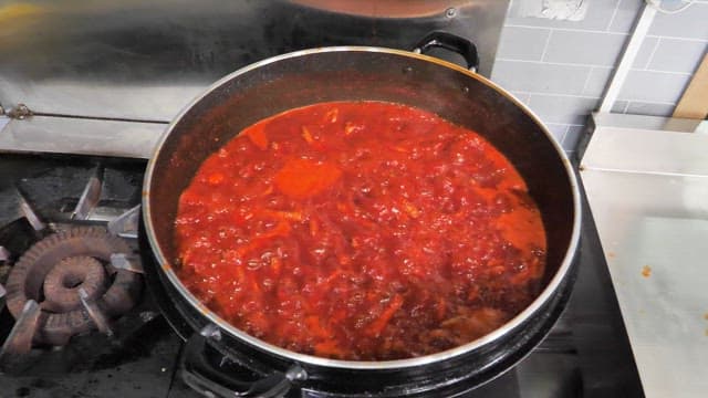 Spicy Braised Chicken Feet in Sauce Simmering on a Stovetop