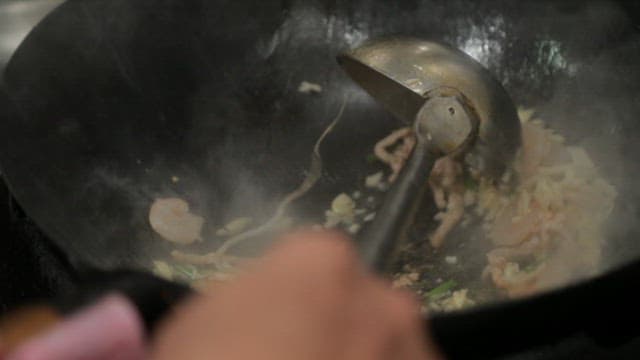 Stir-frying vegetables and meat in a wok