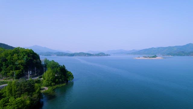 Serene Lakeside Road Amidst Lush Hills