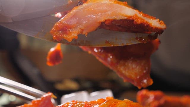 Spicy charcoal-grilled chicken sliced with scissors