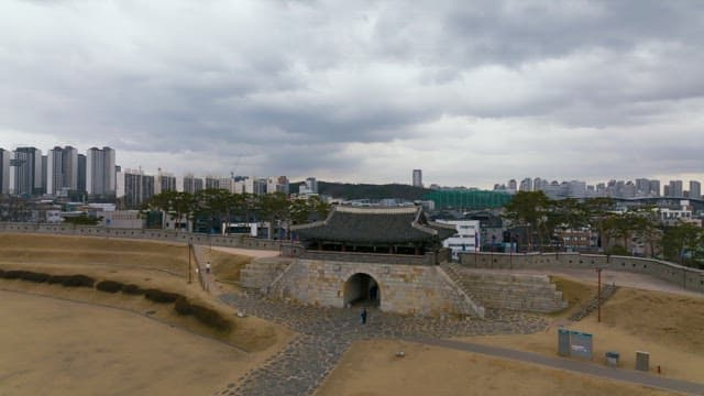 Traditional Korean wall and gate in the middle of the city on a cloudy day