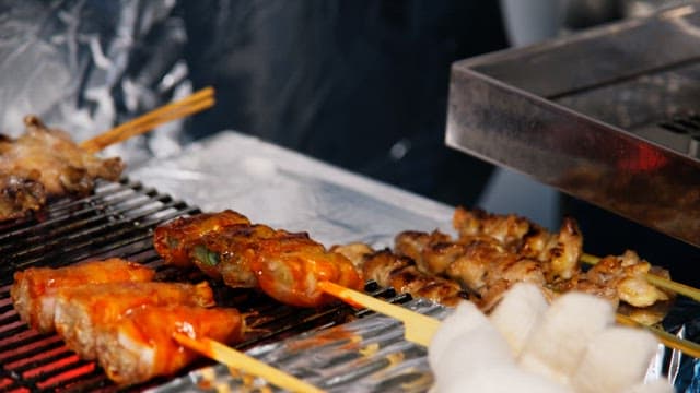 Skewered meat grilling over hot coals