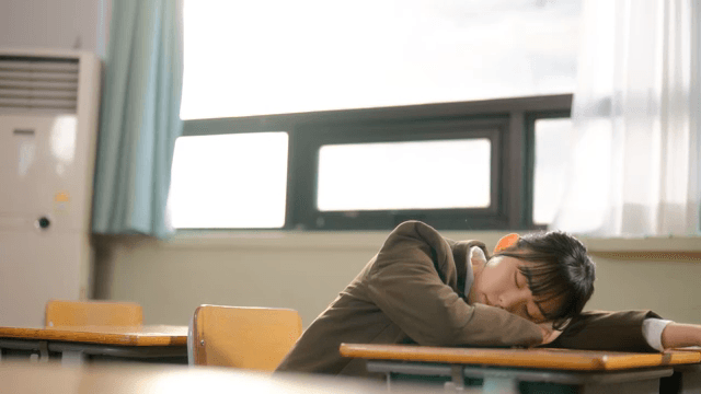 Student resting in a classroom