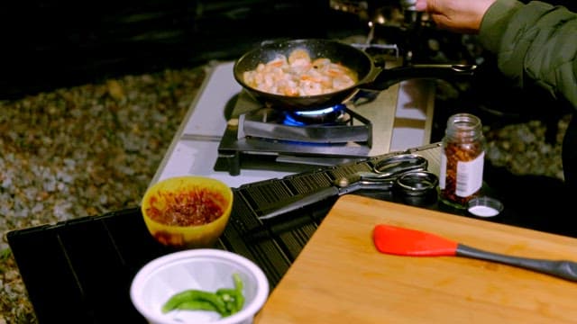 Cooking shrimp in a pan on a portable stove