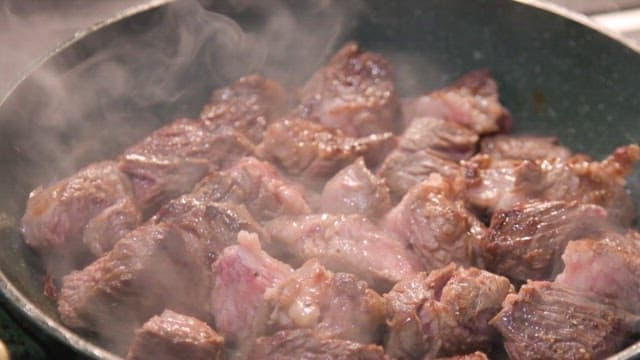 Beef steak pieces being cooked in a pan