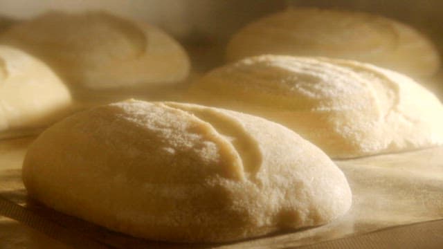 Freshly baked bread loaves rising in the oven