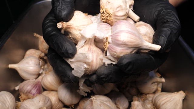 Chef Chopping Garlic on a Cutting Board