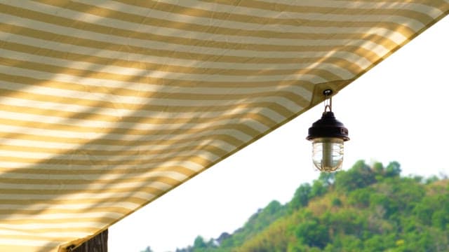 Lantern hanging under striped canopy