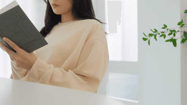 Woman Reading a Book in a Bright Room