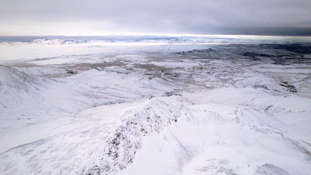 Snow-covered mountains under a cloudy sky