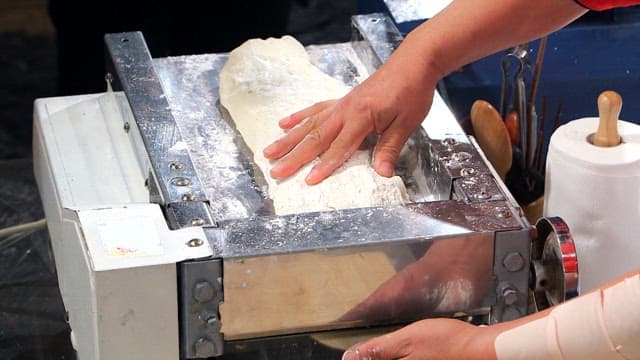 Dough being processed through a machine