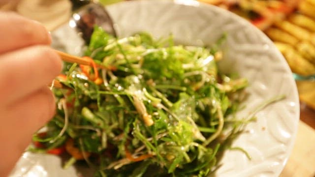 Fresh Salad Being Tossed with Chopsticks