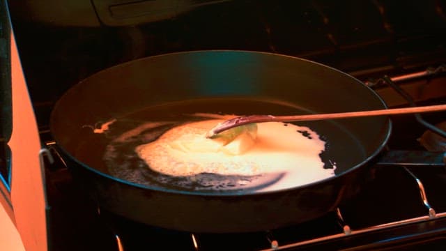 Toast being prepared with bread and butter in a frying pan