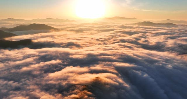 Sunset rising over clouds and mountains