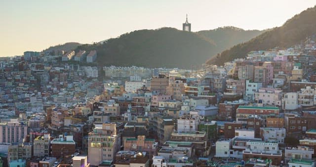 Colorful residential neighborhood at sunset, surrounded by hills