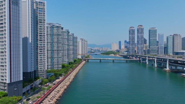 Modern cityscape along a river on a clear day