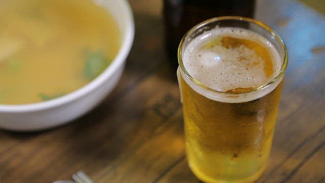Spicy sea snails salad with beer on a table