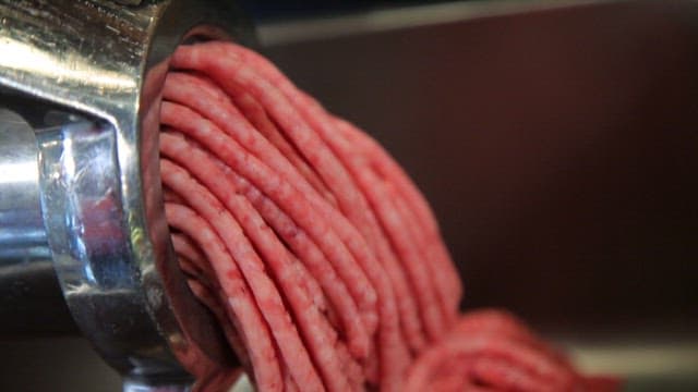 Ground beef being processed in a grinder