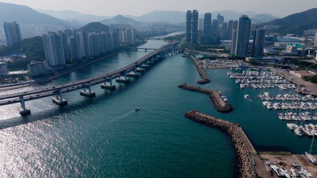 Busan's coastline with skyscrapers, bridges, and yacht marinas